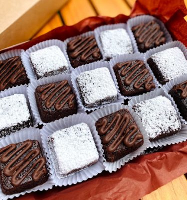 Caja de brownies decorados con azúcar glas y chocolate