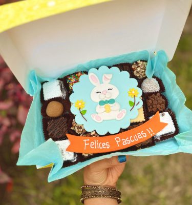 Delicioso Mix Box Conejito con una variedad de postres y una encantadora decoración temática de Pascua en fondant comestible.