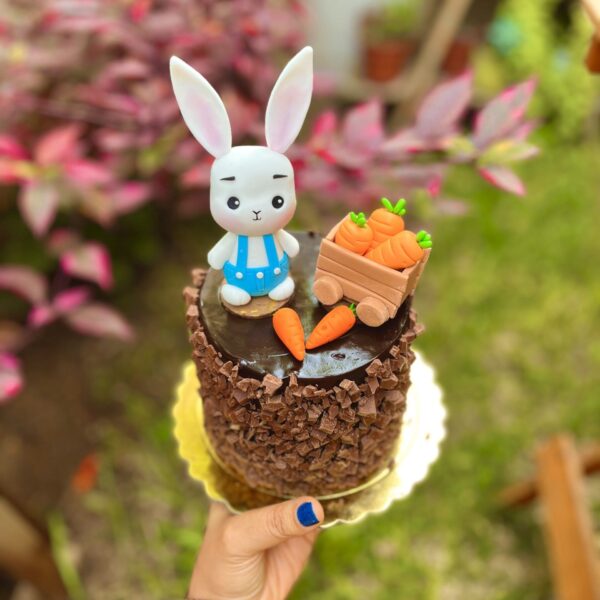 Deliciosa mini torta de chocolate decorada con un encantador conejito y zanahorias.