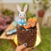 Deliciosa mini torta de chocolate decorada con un encantador conejito y zanahorias.