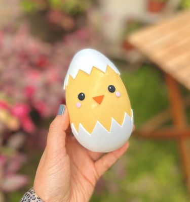 Delicioso Huevo Pollito de Pascua relleno de tentaciones chocolatosas y decorado con un tierno pollito amarillo emergiendo de su cascarón.