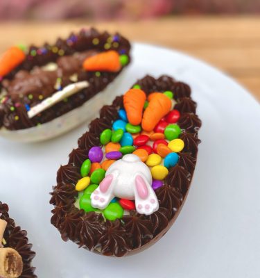 Irresistible huevo de Pascua con decoración adorable de patitas y conejito.