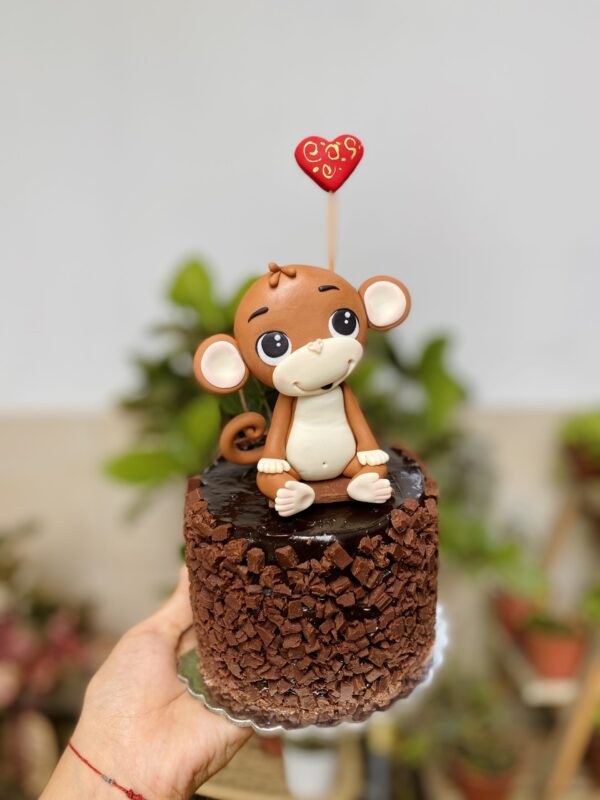Una mini torta artesanal adornada con un simpático monito, ideal para agregar diversión y ternura a tu celebración.