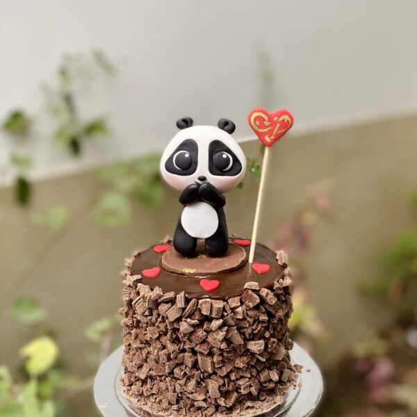 Deliciosa mini torta artesanal decorada con un tierno osito panda, perfecta para cualquier celebración especial.