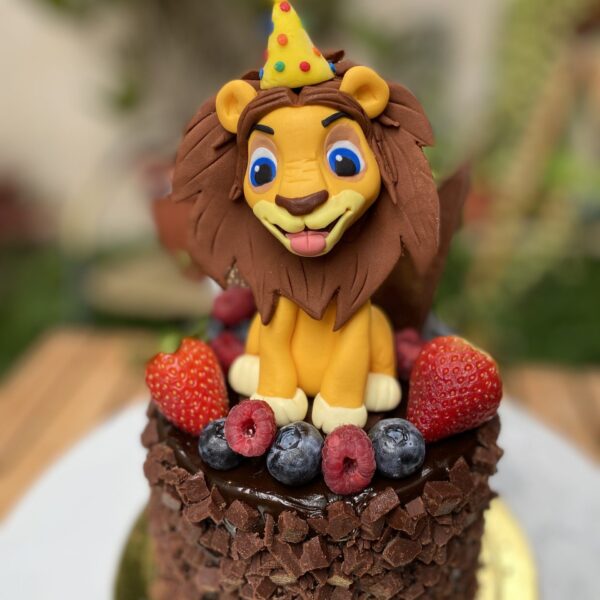 Una mini torta artesanal adornada con un Rey León, una opción majestuosa para celebraciones inolvidables.