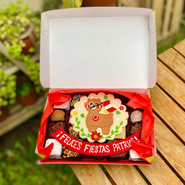 Veinte postres surtidos decorados con fondant con diseño de llama y bandera del Perú, presentados en una caja verde con tramas vintage.