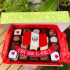 Veinte postres surtidos decorados con arte en oblea de la bandera del Perú, presentados en una caja de diseño marrón vintage con lazo de tela