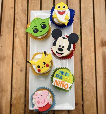 Pack de 6 cupcakes de personajes con buttercream, sabores de vainilla y chocolate, presentados en una caja blanca con ventana.