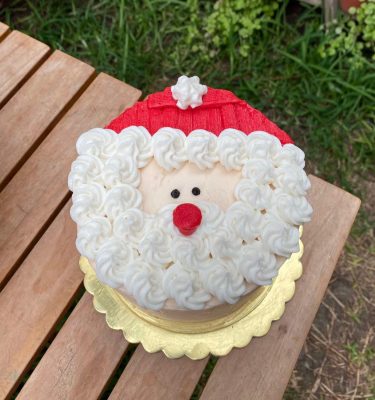Mini torta navideña decorada con la cara de Santa Claus en buttercream