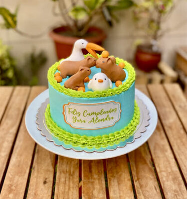 Torta celeste decorada como una pool party con tres capibaras, un pelícano, un patito y mandarina alrededor