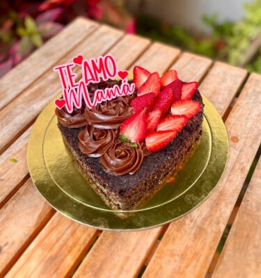 Brownie grande en forma de corazón, decorado con rosetones de fudge y fresas frescas.