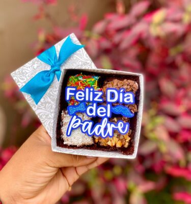 Mini brownie decorado con un topper de cartulina con la frase “Feliz Día del Padre”, acompañado de una corbata michi y un bigote, ideal para celebrar con dulzura y estilo.
