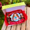 Caja surtida con brownies, trufas y alfajores variados, decorada con topper de fondant de una mamá con su bebé y la frase “Donde está tu amor, está mi paz. Feliz día, mamá”.