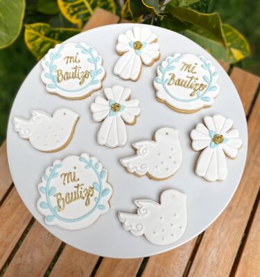 Galletas decoradas con temática de bautizo: palomas blancas, cruces y detalles religiosos en glaseado.