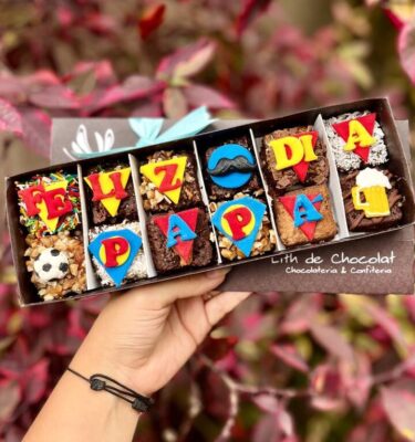 Caja estilo vintage que contiene brownies decorados en fondant con temática del Día del Padre, ideales para regalar.