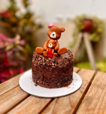 Mini torta de trocitos de chocolate decorada con figuras de fondant de una osita y su bebé osita.