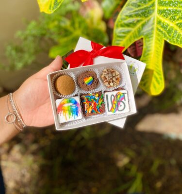 Caja con 3 brownies y 3 trufas decoradas con fondant alusivo al Pride: corazón arcoíris, boca mordida con los colores del Pride y la palabra “LGBT”