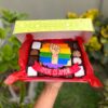 Mix Box Orgullo con brownies, trufas y alfajores decorados con fondant de bandera Pride y la frase “Amor es amor”.
