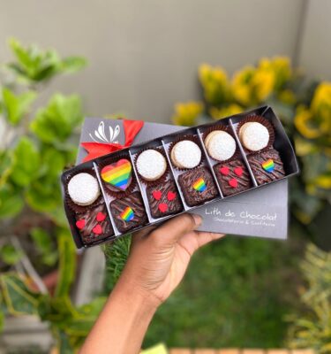 Caja vintage con 6 alfajores y 6 brownies decorados con corazones de fondant en los colores de la bandera Pride.