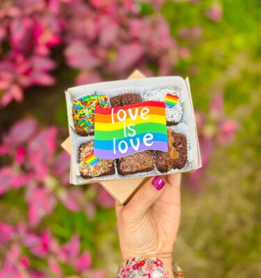 Caja con 6 brownies decorados con fondant en los colores de la bandera del Pride y la frase “Love is Love”.