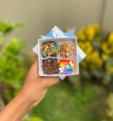 Mini Four con brownie, trufa y alfajor decorado con fondant en forma de cuadrado con los colores del Pride y la palabra “LGBT”.