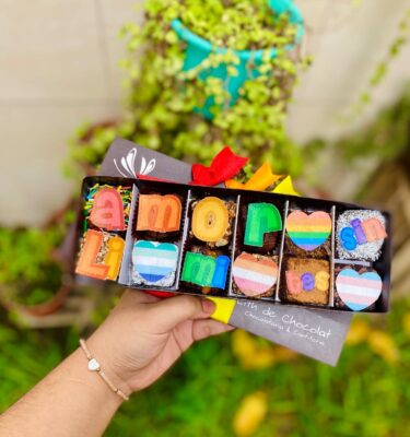 Detalle dulce con topper de papel de arroz que dice “Amor sin límites” y corazones en colores del Pride.