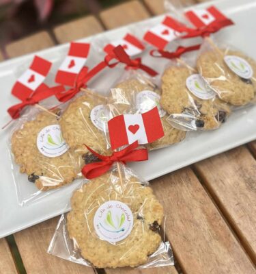 Galletas de avena empaquetadas individualmente, decoradas con una banderita del Perú en la parte superior, ideales para celebrar Fiestas Patrias.