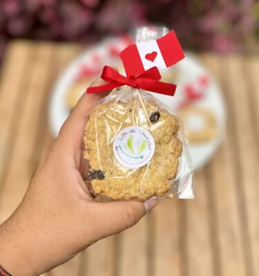 Galletas de avena empaquetadas individualmente, decoradas con una banderita del Perú en la parte superior, ideales para celebrar Fiestas Patrias.