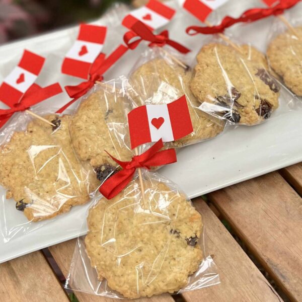 Galletas de avena empaquetadas individualmente, decoradas con una banderita del Perú en la parte superior, ideales para celebrar Fiestas Patrias.