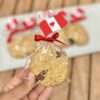 Galletas de avena empaquetadas individualmente, decoradas con una banderita del Perú en la parte superior, ideales para celebrar Fiestas Patrias.