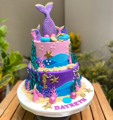 Torta temática de sirena, forrada en fondant con acabados marinos, decorada en la cima con cola de sirena o pulpo, según elección.
