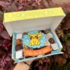 Caja Mix Box con trufas, brownies y alfajores decorados con un Pikachu de fondant y un banner que dice "Feliz Día del Niño"