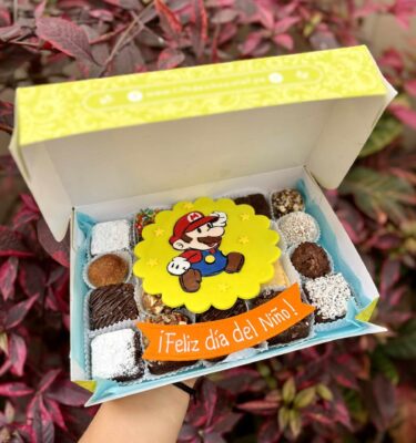 Mix Box de Mario decorado en fondant con trufas, brownies y alfajores, acompañado de un banner que dice “Feliz Día del Niño”