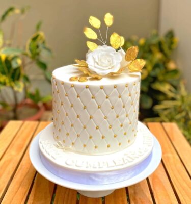 Torta de boda blanca de varios pisos, decorada con diseño capitoné que imita el efecto acolchado, con un acabado elegante y sofisticado.