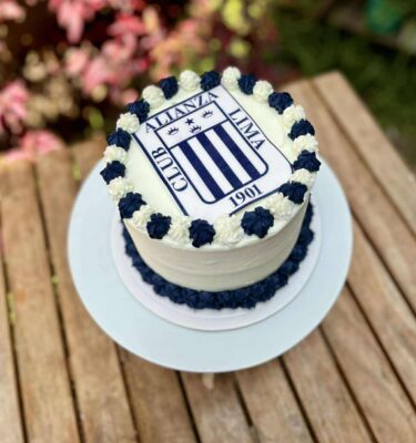 Torta circular bañada en buttercream azul y blanco, decorada con los colores de Alianza Lima y con el logo del equipo en papel de arroz en el centro.
