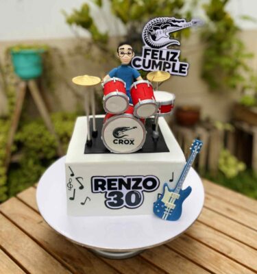 Torta de un piso decorada con un baterista en 3D de azúcar junto a su batería.