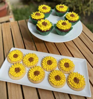 Pack de 6 cupcakes, pack de 6 galletas y pack de 6 alfajores decorados con buttercream amarillo en forma de girasol, con centro de manjar blanco.