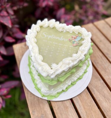 burncake en forma de corazón, bañado en buttercream blanco y verde.