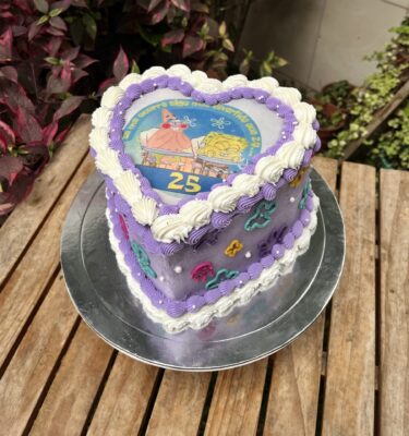 Burncake temática Bob Esponja, bañado en buttercream lila con detalles blancos, perlas comestibles y flores en buttercream inspiradas en Fondo de Bikini.