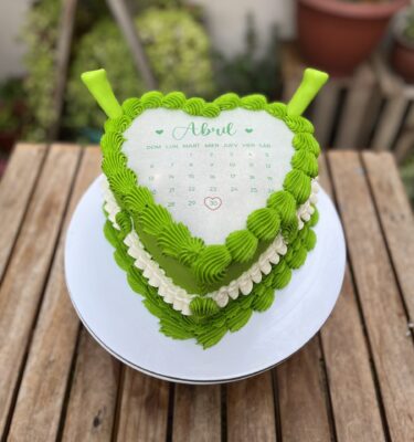 Burncake temática Shrek, bañada en buttercream verde con detalles en blanco y orejitas 3D de fondant a los lados.