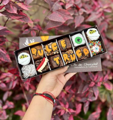 Caja de brownies decorados con temática de Halloween, con detalles en fondant de momias, ojos, dientes de vampiro y la frase “Dulce o truco”.