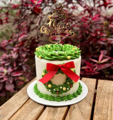 Torta decorada en buttercream con una corona navideña elaborada en buttercream.