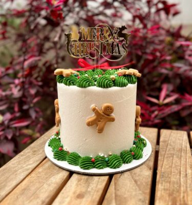 Torta decorada en buttercream con muñequitos de jengibre en fondant.