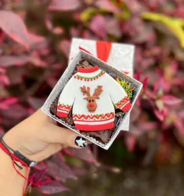 Mini four con 4 brownies decorados con un suéter navideño en fondant, perfectos para compartir o regalar en esta dulce temporada.