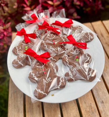 Galletas de jengibre artesanales decoradas, con formas navideñas y detalles dulces, ideales para compartir en temporada festiva.