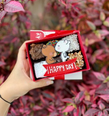 Caja Mini Six de San Valentín con 6 brownies individuales, cada uno con diferentes toppings y decoraciones en fondant 2D de los ositos Milk y Mocha, presentados como un detalle dulce y romántico.
